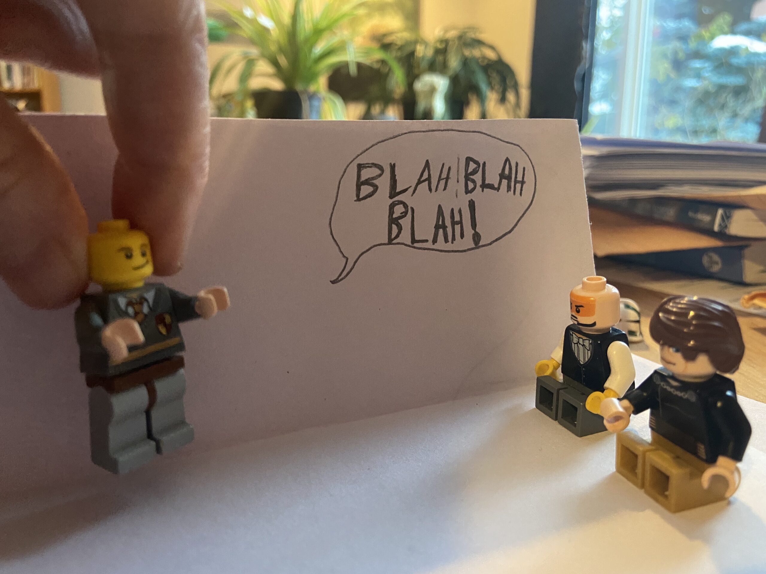 A lego figure is being carried away from his lego students because as he gives a boring lecture.